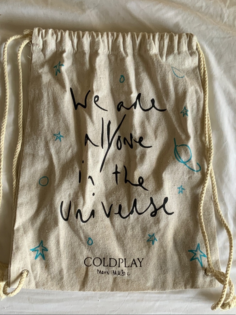 Cold Play 'We Are All One In The Universe' Cream Drawstring Tote